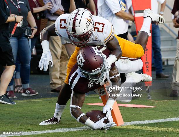 Trayveon Williams of the Texas A&M Aggies is knocked out of bounds by Nick Ingram of the Louisiana Monroe Warhawks before he can reach the endzone in...