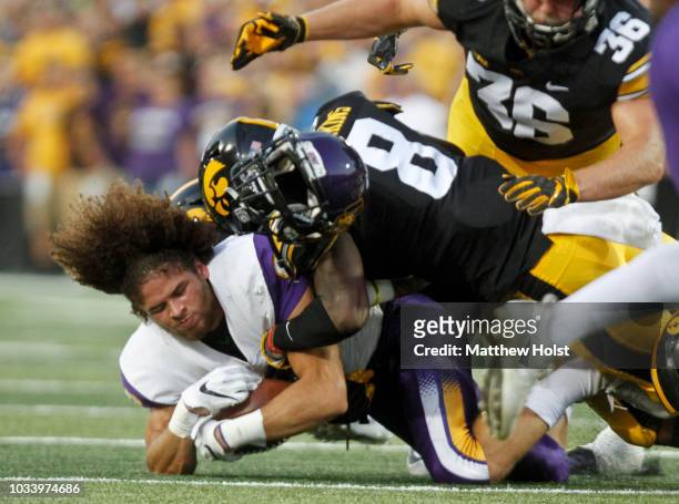 Runningback Xavior Williams of the Northern Iowa Panthers loses his helmet as he is brought down on a return in the first half by defensive back Matt...