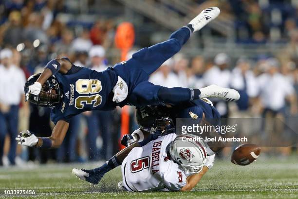 Andy Isabella of the UMass Minutemen is unable to hold onto the ball after being hit by Richard Dames of the Florida International Panthers at FIU...