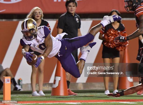 Myles Gaskin of the Washington Huskies leaps into the end zone for a touchdown in the first half of a game against the Utah Utes at Rice-Eccles...