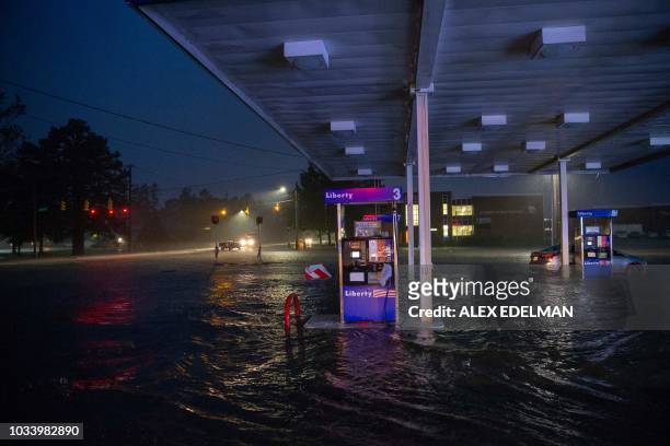 Rising flood waters overtake a gas station in Lumberton, North Carolina, on September 15, 2018 in the wake of Hurricane Florence. - Besides federal...