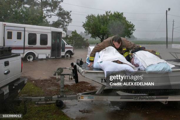 Lumberton firefighter holds on to two nursing home patients as a member of the Cajun Navy drives his truck during the evacuation of a nursing home...