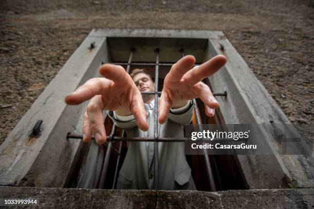 homem de negócios atingindo prisão janela com as mãos - prison lock - fotografias e filmes do acervo