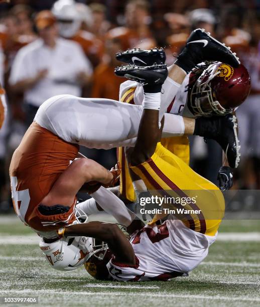 Andrew Beck of the Texas Longhorns is tackled by Ajene Harris of the USC Trojans and Marvell Tell III in the second half at Darrell K Royal-Texas...