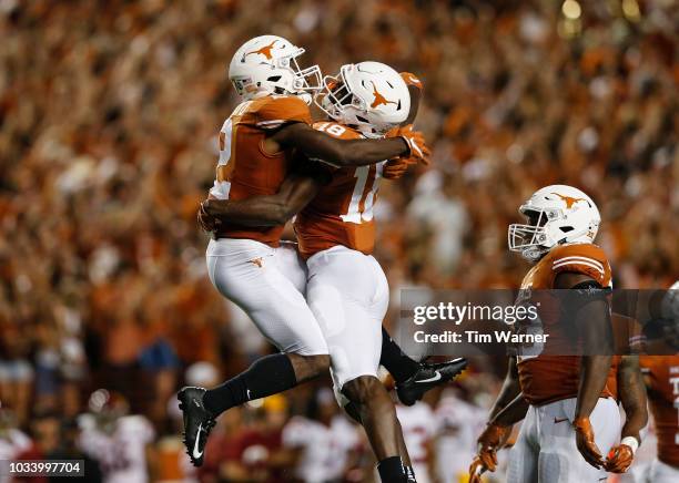 Davante Davis of the Texas Longhorns celebrates with Kris Boyd of the Texas Longhorns after a first half interception against the USC Trojans at...