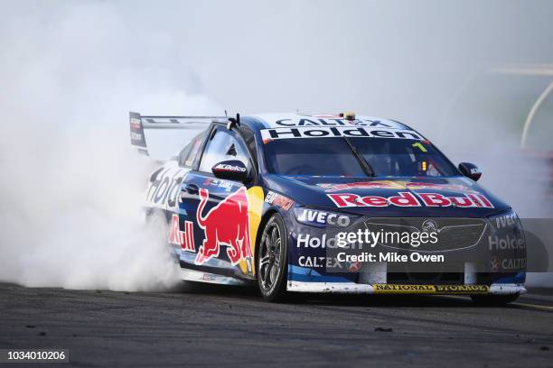 Jamie Whincup driver of the Red Bull Holden Racing Team Holden Commodore ZB does a burnout after winning the Supercars Sandown 500 at Sandown...