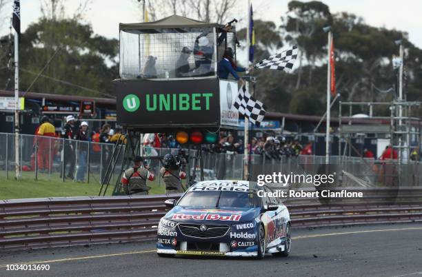 Jamie Whincup driver of the Red Bull Holden Racing Team Holden Commodore ZB crosses the line to win the Sandown 500 at Sandown International Motor...