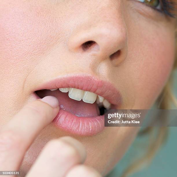 detail of a woman touching her lip with a finger - 指をくわえる ストックフォトと画像