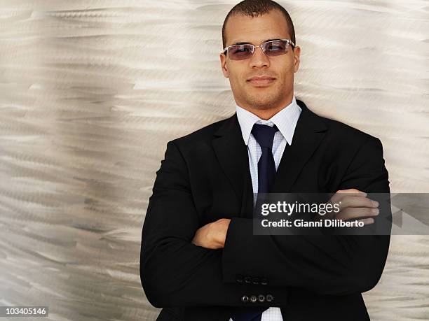 portrait of a businessman with his arms crossed, wearing sunglasses - black suit sunglasses stock pictures, royalty-free photos & images