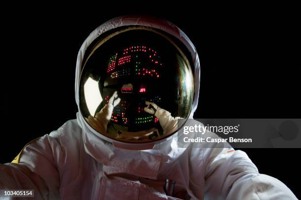 an astronaut in space making adjustments to a control panel - spacesuit stock pictures, royalty-free photos & images