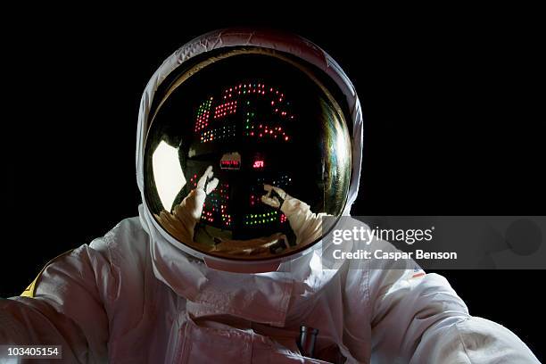 an astronaut in space making adjustments to a control panel - roupa de astronauta imagens e fotografias de stock