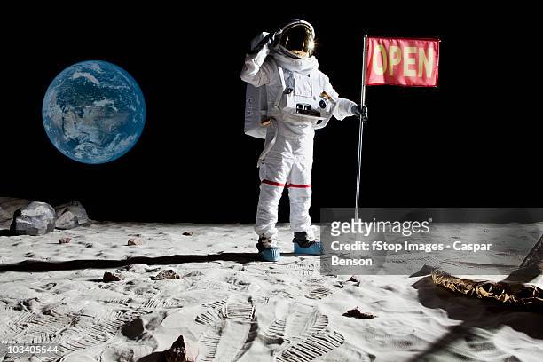 an astronaut on the moon saluting next to a flag with open on it - cosmonaut stock pictures, royalty-free photos & images