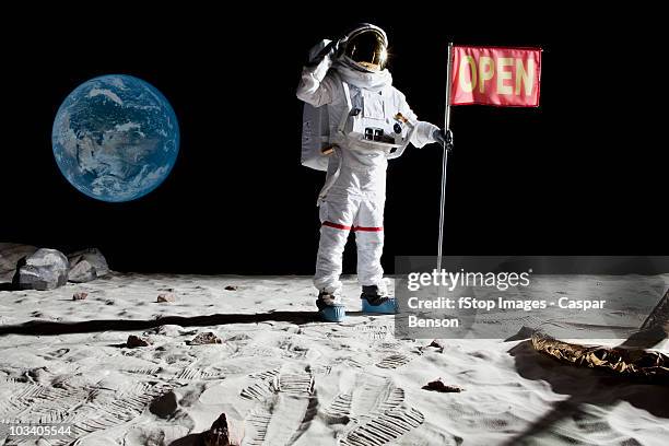 an astronaut on the moon saluting next to a flag with open on it - roupa de astronauta imagens e fotografias de stock
