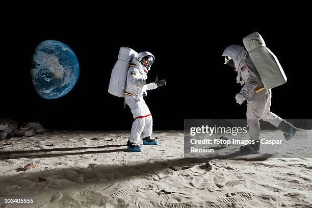 two astronauts playing soccer on the moon - astronaut stock pictures, royalty-free photos & images