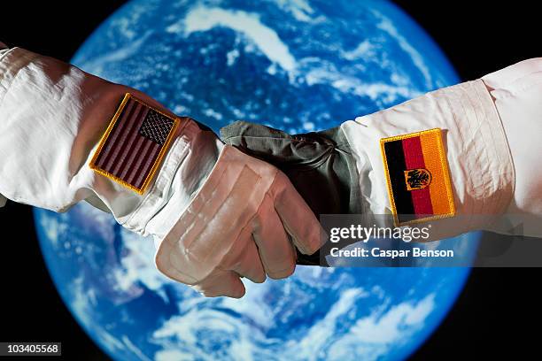 an american astronaut shaking hands with a german astronaut - astronaut hand stock pictures, royalty-free photos & images