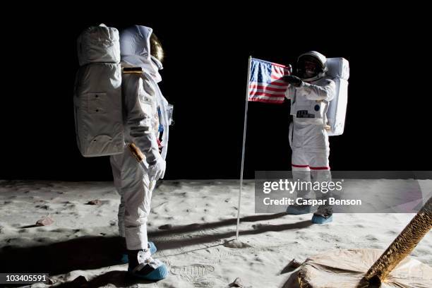 two astronauts on the moon, an american flag in between them - vehículo espacial fotografías e imágenes de stock