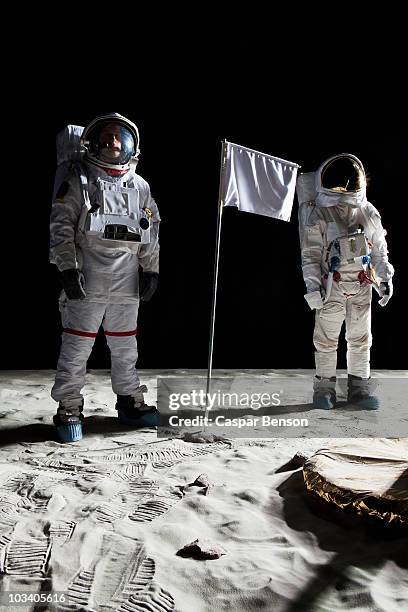 two astronauts on the moon, a blank white flag in between them - space suit stock pictures, royalty-free photos & images