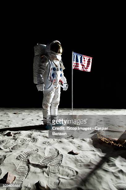 an astronaut on the moon standing next to an american flag - andando na lua - fotografias e filmes do acervo