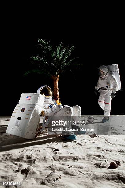 two astronauts on the moon enjoying some leisure time - astronaut moon stockfoto's en -beelden