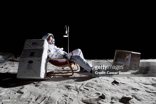 an astronaut on the moon watching television - astronaut sitting stock pictures, royalty-free photos & images