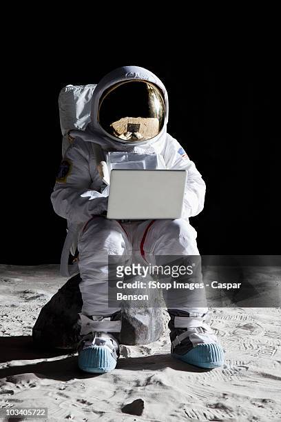 an astronaut on the moon sitting on a rock using a laptop - astronaut sitting stock pictures, royalty-free photos & images