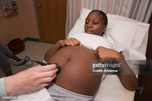 a pregnant woman receiving an ultrasound - prenatal care stock pictures, royalty-free photos & images