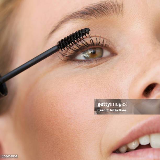 detail of a young woman applying mascara - mascara stockfoto's en -beelden