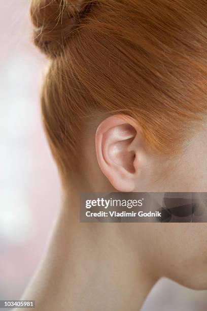 detail of a redheaded woman's ear and neck - ears photos et images de collection