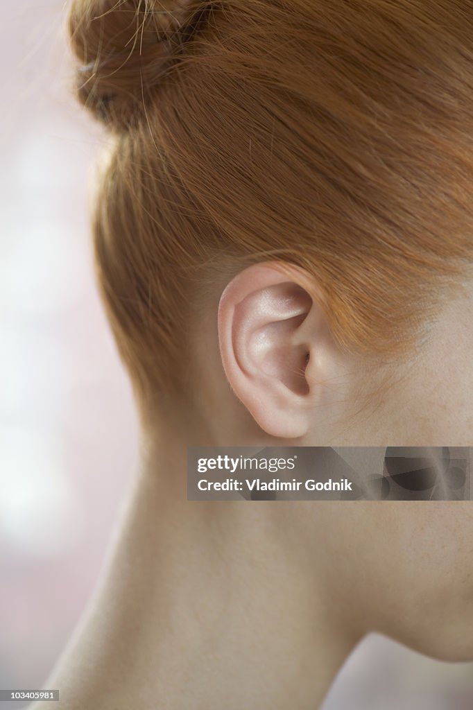 Detail of a redheaded woman's ear and neck