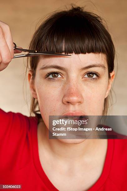 a woman trimming her own bangs - bangs hair stock pictures, royalty-free photos & images