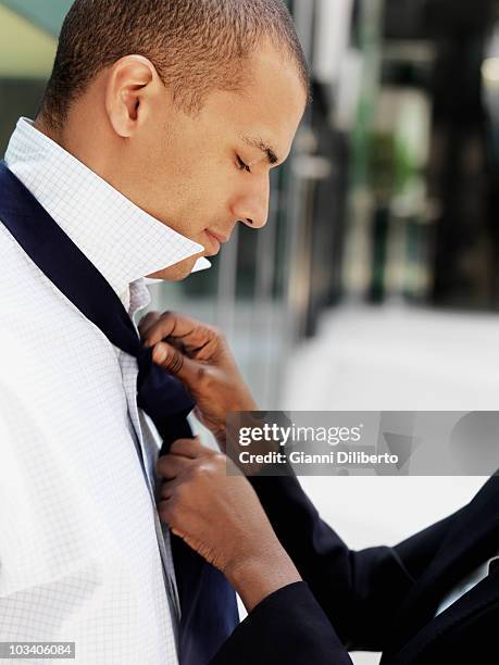 a businesswoman tying her boyfriend's tie - man tying tie stock pictures, royalty-free photos & images