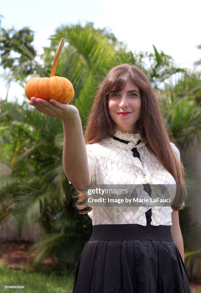 Elegant woman holding tiny pumpkin