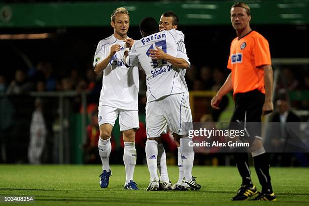 Jefferson Farfan of Schalke celebrates his team's second goal with team mates Ivan Rakitic and Lukas Schmitz as Thomas Scheuring of Aalen reacts...