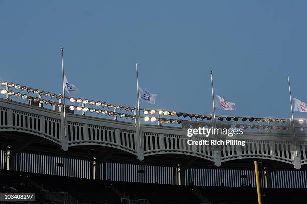 The New York Yankees World Championship flags fly at half mast prior to the Tribute to George M. Steinbrenner III before the game against the Tampa...