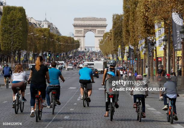 People ride bicycles as they enjoy a vehicle-free day in front of the Arc de Triomphe in Paris, on September 16, 2018. - Europe should hold an annual...