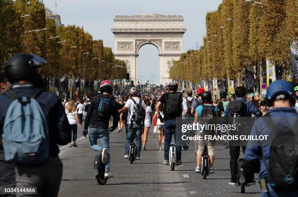 People use monowheel as they enjoy a vehicle-free day in front of the Arc de Triomphe in Paris, on September 16, 2018. - Europe should hold an annual...