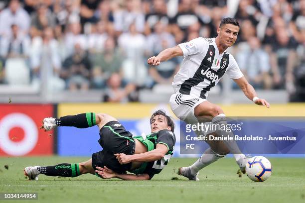 Cristiano Ronaldo of Juventus competes for the ball with Filip Djuricic of US Sassuolo during the serie A match between Juventus and US Sassuolo at...