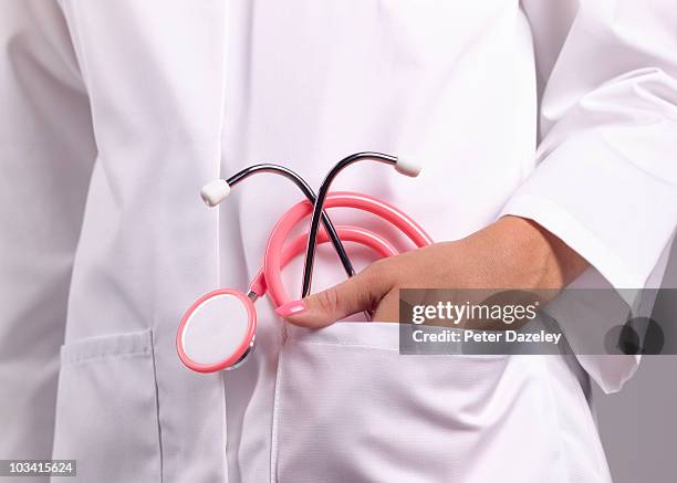 feminine doctor with pink stethoscope in pocket - gynaecologist stock-fotos und bilder