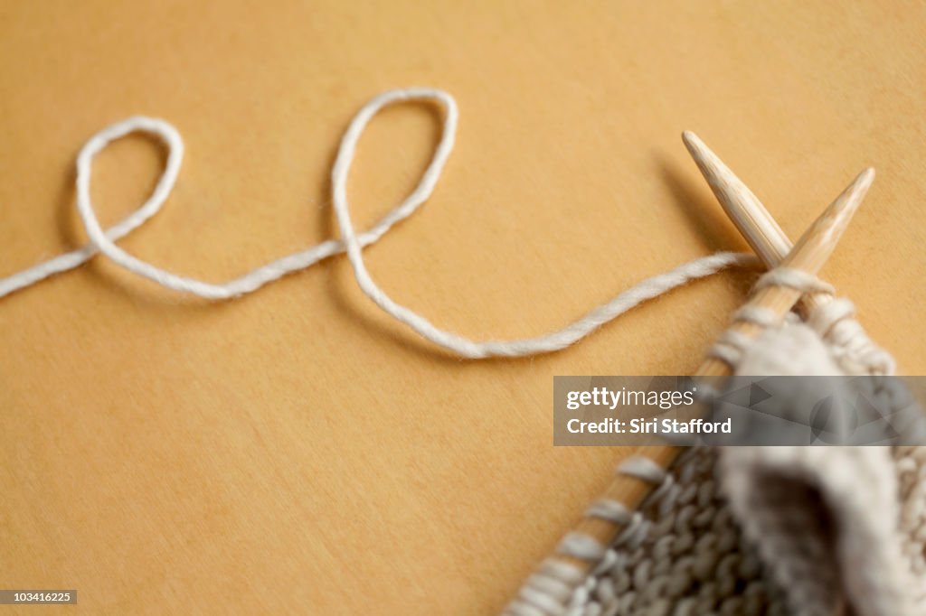 Line of wool string connected to knitting project