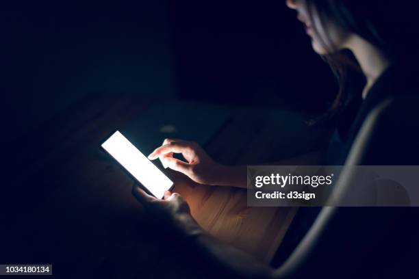 close up of woman using smartphone in darkness - ipad glow foto e immagini stock