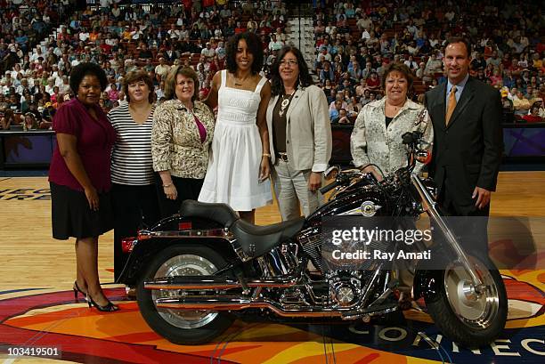 Former Connecticut Sun player Nykesha Sales poses in front of a motorcycle intended for drawing during the Connecticut Sun v. Indiana Fever game on...