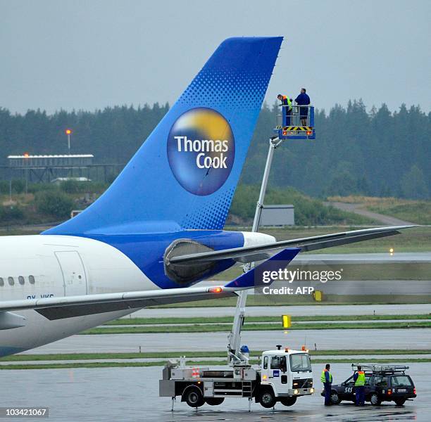 Technicians examine the tail on a Thomas Cook Airbus 330 after an emergency landing at Arlanda Airport in Stockholm, on August 17, 2010. The plane...