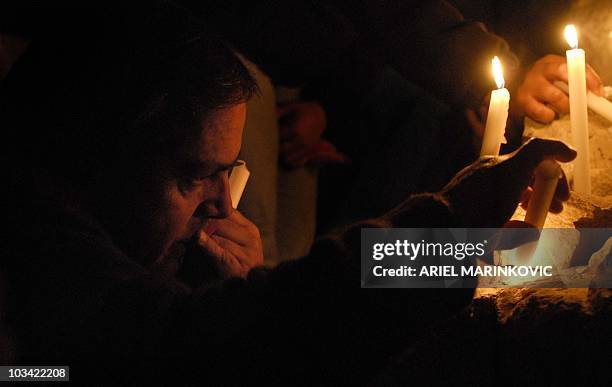 Relatives of trapped miners pray and light candles on an altar outside the San Esteban gold and copper mine, near the city of Copiapo, in the arid...