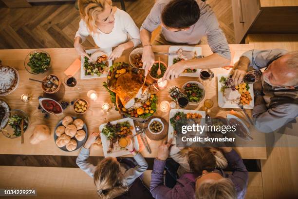 above view of extended family talking at thanksgiving dinner. - high angle view family stock pictures, royalty-free photos & images