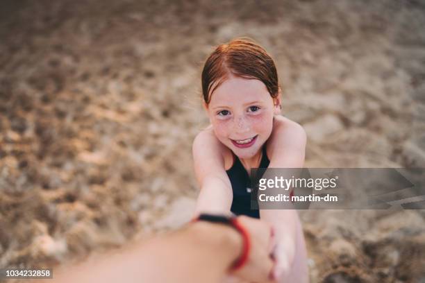 rothaarige mädchen am strand will mit seinem vater spielen - naughty daughter stock-fotos und bilder