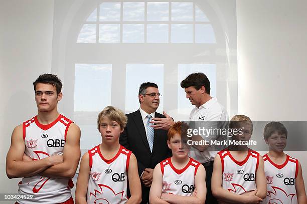Australian Football League CEO Andrew Demetriou and Swans Coach Paul Roos chat as Swans Academy players pose during a Sydney Swans AFL media...