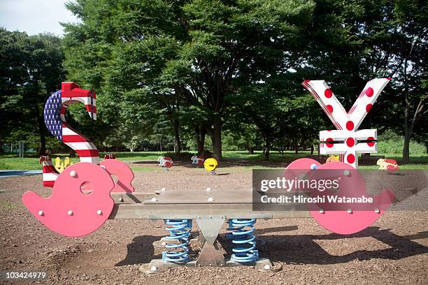 money symbols balancing on seesaw - yen sign stock pictures, royalty-free photos & images