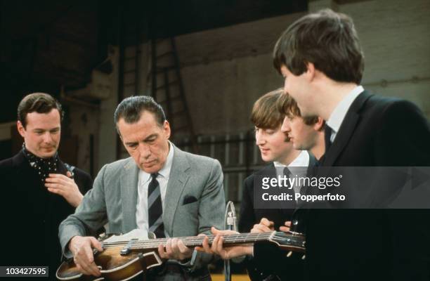 With their manager Brian Epstein , members of the British Rock group the Beatles watch as American television host Ed Sullivan tries out Paul...
