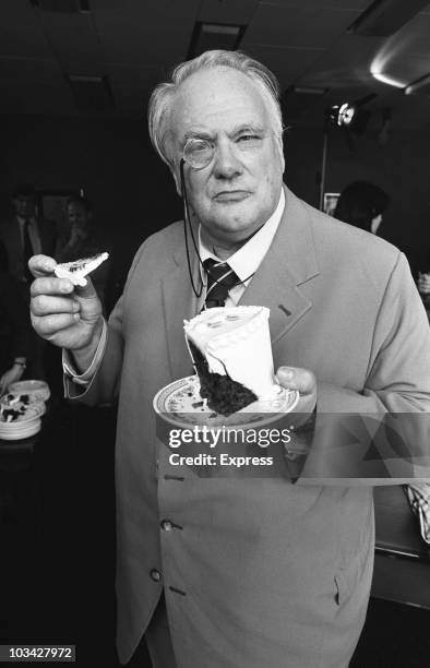 British astronomer and television presenter Patrick Moore with some cake on April 21, 1982.