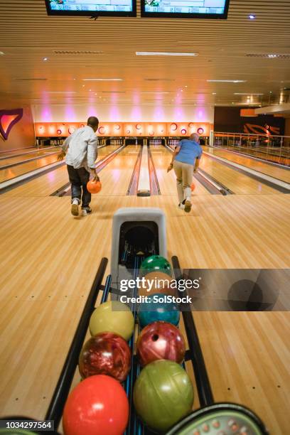 zwei ältere männer 10-stift bowlingspiel - bowlingbahn stock-fotos und bilder